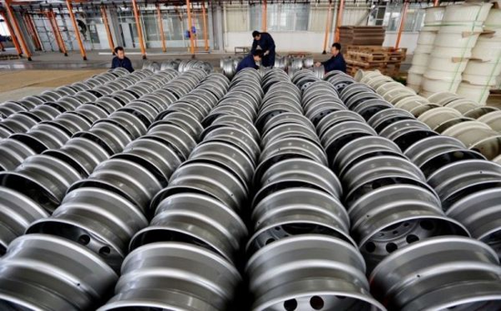 资料图片:工人在位于江苏连云港的一家钢轮工厂内码放产品.